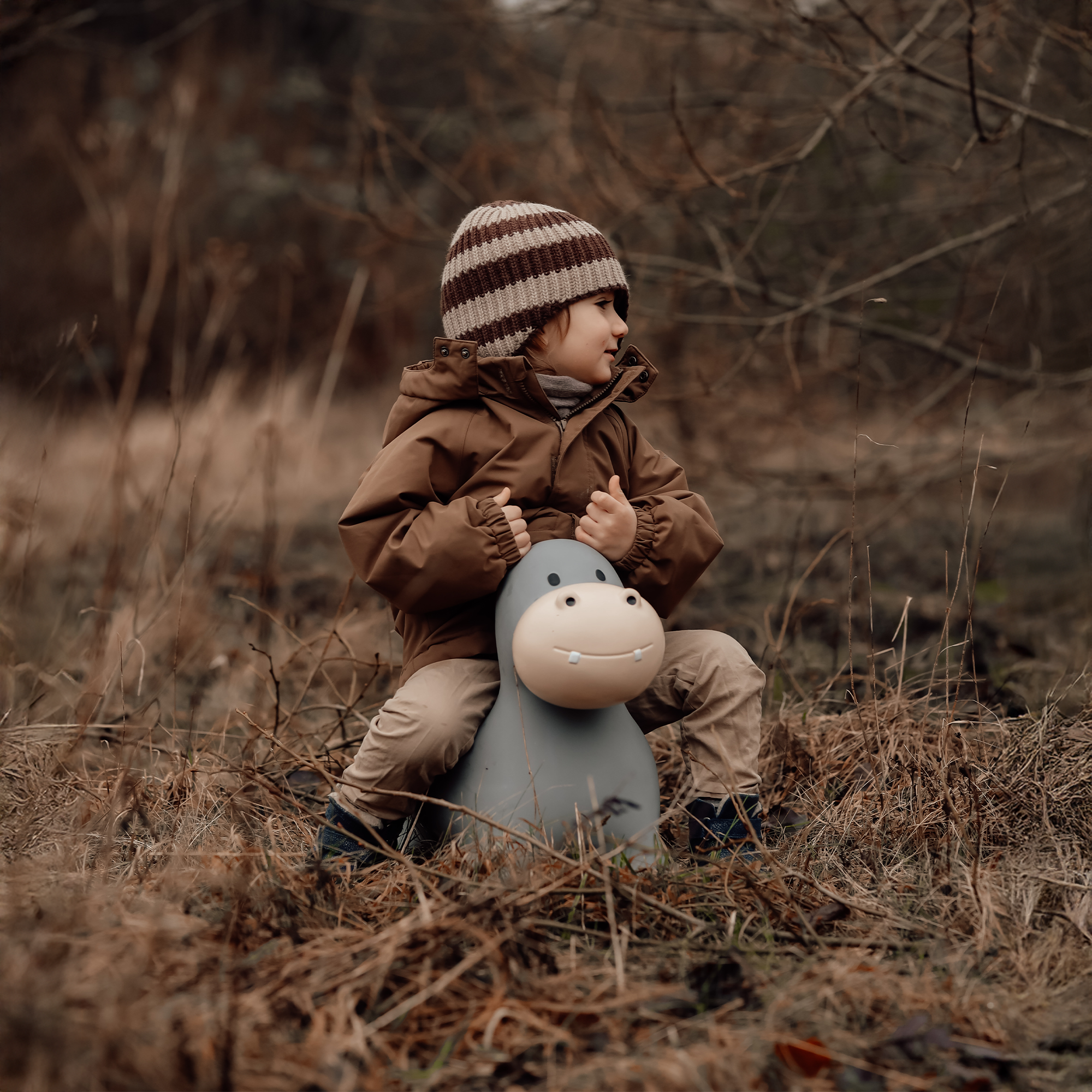 Child holding Holger the hippo bouncing toy while walking through the woods – Find That Hippo