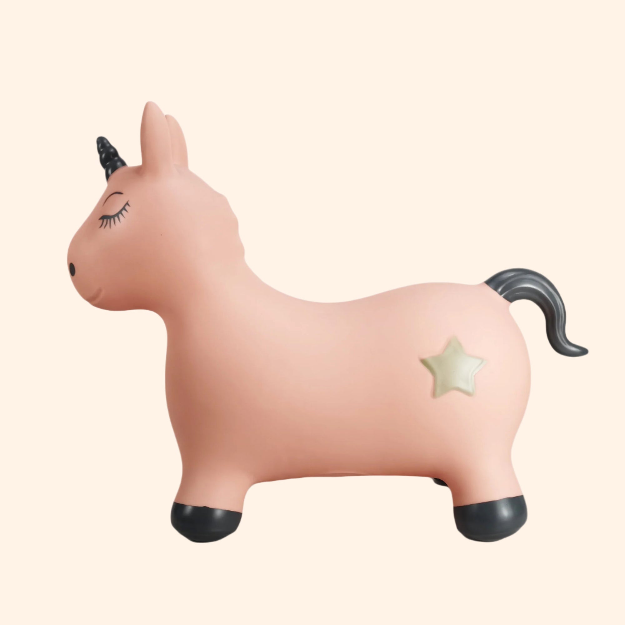 Luna the Unicorn – side view of the pink inflatable jumping toy, showing its black horn, hooves, and golden star